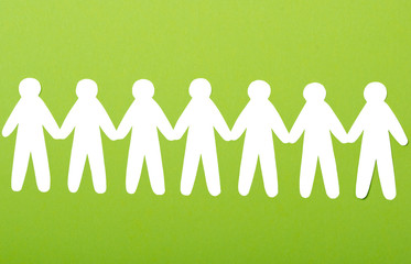 team of paper people on green background