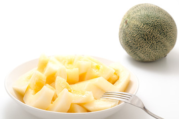 カットした黄色系メロンとフォーク