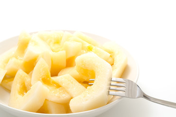 カットした黄色系メロンとフォーク