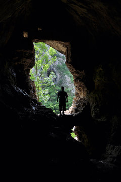Man standing in front of a cave entrance