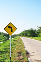 A yellow right turn road sign in country from Thailand
