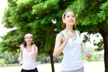 Fototapeta premium Beautiful young women running in park. Portrait of asian.