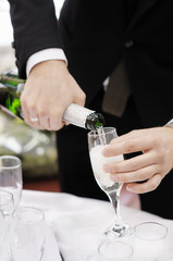 Pouring champagne into a glass on a wedding celebration
