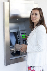 Fototapeta na wymiar Kobieta zbiera pieniądze z bankomatów