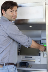 Mann hebt Geld am Geldautomaten ab