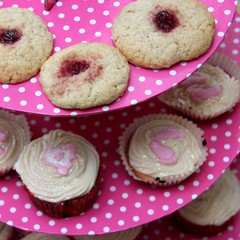 Homemade biscuits and fairy cakes on a pink polka dot tray