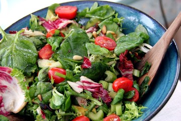 Fresh Salad on a blue dish with wooden spoon