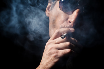 The man smokes a cigaret