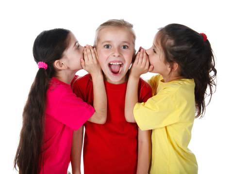 Two girls whispering something to third girl