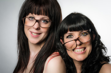 Two smiling girls with crooked glasses