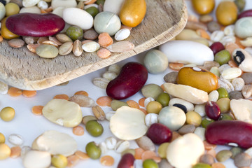 Mixed vegetables on wooden spoon and a white background