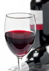 Red wine in glass and bottles, isolated, wihite background