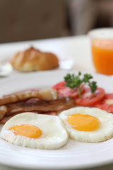 Breakfast with bacon , fried egg and orange juice