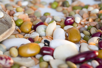 Mixed vegetables on wooden spoon and a white background