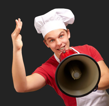 portrait of happy cook man shouting using megaphone over black b