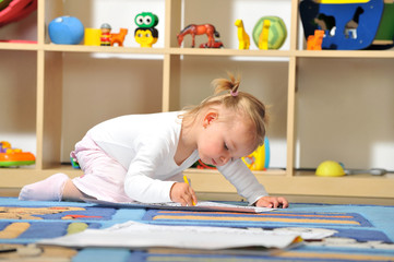 Fototapeta premium Kleines Mädchen malt mit Buntstiften