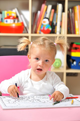 Fototapeta premium Kleines Mädchen malt mit Buntstiften
