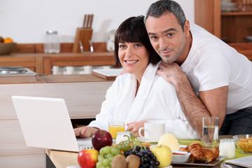 Obraz na płótnie Canvas Couple eating breakfast in the kitchen