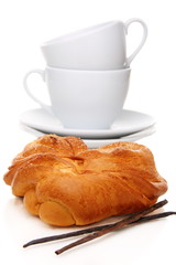 Bun, vanilla and tea cups.