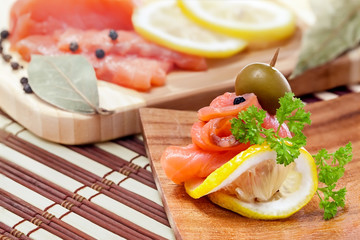 Salmon snack on the wooden plate, studio shot