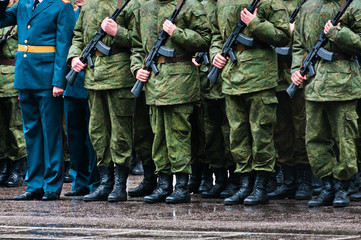 Soldiers stand in formation with officer