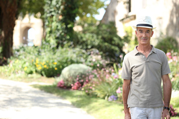 A mature man at a countryside house.