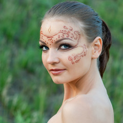 A young woman with a body-art on the face