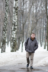 Middle age man walking in snow park