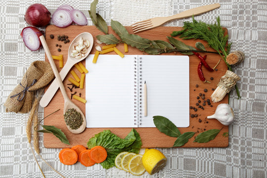 notebook for recipes and spices on wooden table