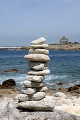 empilement de galets sur fond de ciel bleu en bretagne