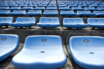 blue ordered rubber seats in a sports track field