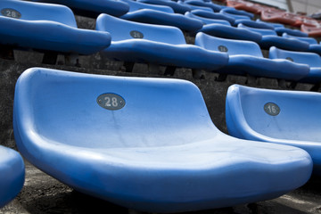 blue ordered rubber seats in a sports track field