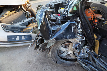 Crumpled and broken hoods of two collided cars after accident