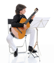 Fototapeta premium Little boy musician playing guitar