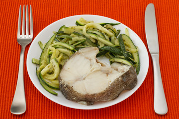 boiled fish with vegetables in white plate