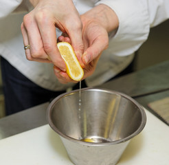 Chef is adding lemon juice in sauce