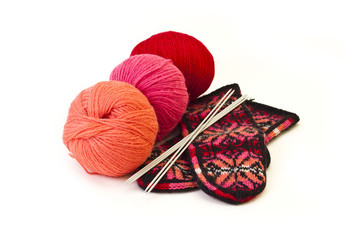 Hanks of wool, knitting needle and a mitten.