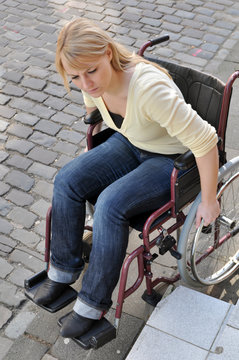 Rollstuhlfahrerin vor Hindernis