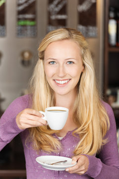 blonde frau genießt eine tasse kaffee