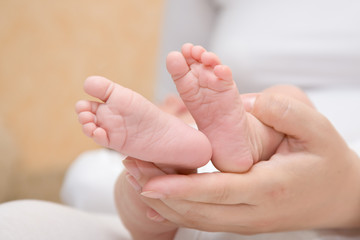 Obraz na płótnie Canvas Newborn baby feet w ręce matki
