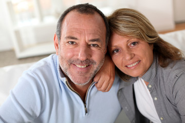 Portrait of happy senior couple sitting in sofa