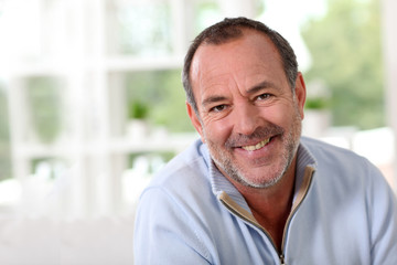 Portrait of senior man sitting in sofa at home