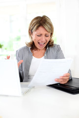 Portrait of senior woman getting crazy with bills