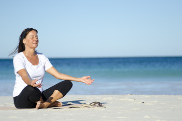 Fototapeta na wymiar Meditating, relaxing, exercising woman at beach