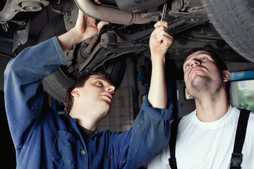 Two Car Mechanic repairing car - obrazy, fototapety, plakaty