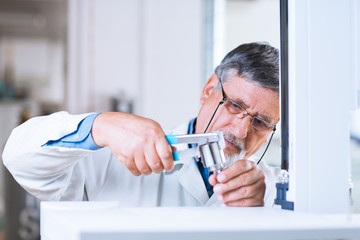 senior male researcher carrying out scientific research in a lab