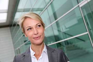 Mature businesswoman standing in front of modern building