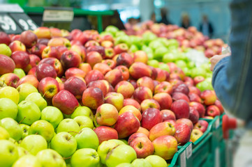 Variety of apples in boxes in supermarket
