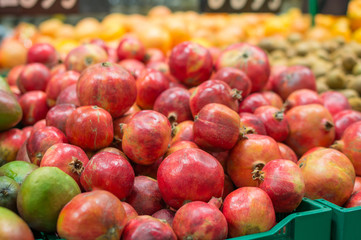 Variety of pomegranate fruits in boxes in supermarket