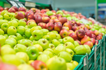 Variety of apples in boxes in supermarket